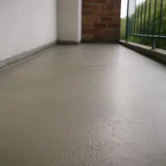 Świeżo wylana, szara wylewka na balkon, gotowa na nowe wykończenie.