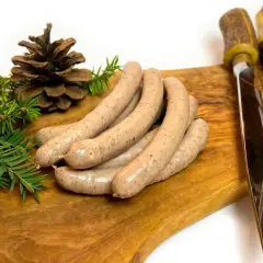 Kiełbasa z dzika na desce, z gałązkami iglaków i szyszką. Idealne jakie przyprawy do kiełbasy z dzika?