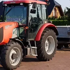 Czerwony traktor Zetor z przyczepą. Zastanawiasz się, ile kosztuje prawo jazdy na traktor?