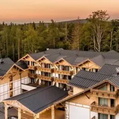 Nowy hotel w górach, oferujący zatrudnienie, otoczony lasem.