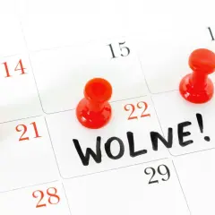 Kalendarz z zaznaczonymi dniami i pinezkami, napis "Wolne!