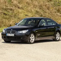 Czarne BMW 535d na tle zielonego wzgórza, gotowe na podróż.