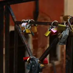 Kłódki miłości na moście. Jedna z nich ma napis "ti amo - tłumaczenie" i serce.