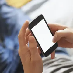 Dłonie trzymają smartfon, ekran świeci pustym blaskiem. Zastanawiasz się, jak schłodzić telefon? Oto kilka wskazówek.