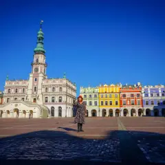 Kobieta na Rynku Wielkim w Zamościu, gdzie można zwiedzić renesansowy ratusz i kolorowe kamienice.