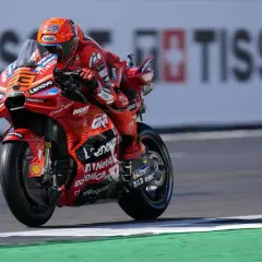 Piloto de Ducati en carrera, con su traje rojo y casco naranja. El número 23 es visible. Mar Márquez compite en la pista.