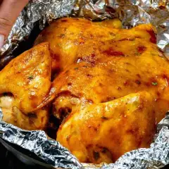 Un succulento petto di pollo dorato, cotto in carta stagnola, pronto per essere gustato.