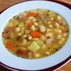 Pyszna zupa fasolowa przepis babci. Biała fasola, ziemniaki, marchewka i kawałki wędzonki w aromatycznym bulionie.