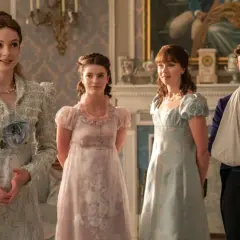 Familjen Bridgerton samlad i en elegant salong. Kvinnorna bär tidstypiska klänningar, medan en av bröderna har armen i en mitella.