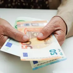 Dłonie trzymają euro. Ile wynosi renta chorobowa w Niemczech po 10 latach pracy?