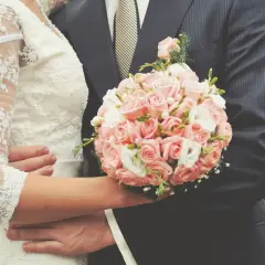 Para śmieje się, trzymając bukiet róż. Idealny moment na śmieszne życzenia na ślub!