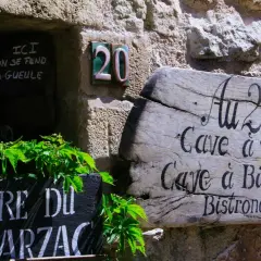 Bonjour! Drewniany szyld "Au 20" zaprasza do piwnicy z winami i piwami. Obok tablica z napisem "Biere du Arzac".