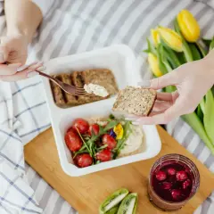 Zdrowy posiłek: pełnoziarniste pieczywo, hummus, pomidorki i owoce leśne. Idealne, by dowiedzieć się, co jeść na zaparcia.