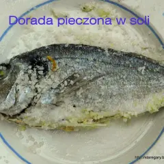 Dorada pieczona w soli, cała ryba pokryta grubą warstwą soli, gotowa do pieczenia.