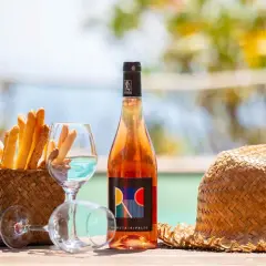 Un bicchiere di vino dolce dell'Elba, grissini croccanti e un cappello di paglia, perfetti per un aperitivo al mare.