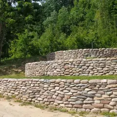 Trzy poziomy kamiennego mureu oporowego, idealny pomysł na zagospodarowanie skarpy.
