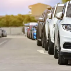 Rząd białych i ciemnych samochodów na parkingu. Może to być scena z transakcji, gdzie nastąpiło zaniżenie wartości samochodu na umowie.