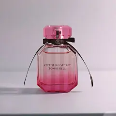 Różowa butelka kultowych perfum damskich Victoria's Secret Bombshell z czarną wstążką.