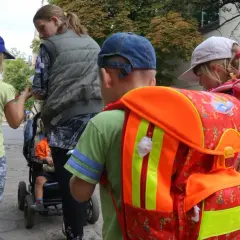 Dzieci z plecakami, gotowe do szkoły. W tle wózek z dzieckiem. Ponad 300 wniosków elektronicznych czeka na rozpatrzenie.