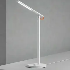 Un flexo vintage blanco con un toque naranja, ideal para iluminar tu espacio de trabajo con estilo.