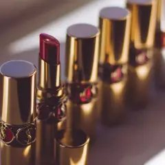 Une rangée de rouges à lèvres dorés, dont un ouvert révélant quelle couleur de rouge à lèvres intense.