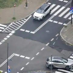 Na skrzyżowaniu równorzędnym biały SUV i srebrny crossover czekają na zielone światło.