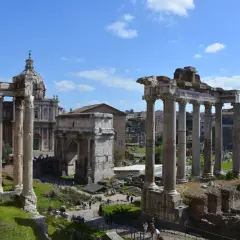 Le rovine del Foro Romano, con colonne imponenti e un arco trionfale, sotto un cielo azzurro. Un assaggio di Roma 72h.