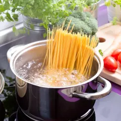 Spaghetti kochen in sprudelndem Wasser. Daneben frisches Gemüse wie Brokkoli, Karotten und Tomaten. So einfach ist es, wie koche ich nudeln!