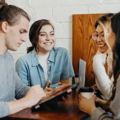 Hej! Grupa przyjaciół przy kawie, dyskutuje nad tabletem.