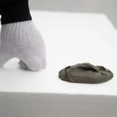 Ręka w rękawicy przygotowuje masę do wylewki na styropianie. Kluczowe jest, ile styropianu pod wylewkę zostanie użyte.