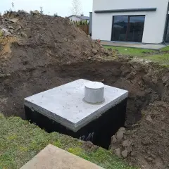 Rozpoczęty montaż zbiornika na deszczówkę w wykopie obok domu.