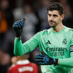 Thibaut Courtois, jeden z kapitanów Realu Madryt, w zielonej koszulce bramkarskiej, pokazuje kciuk w górę.