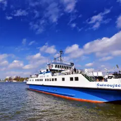 Prom "Świnoujście" z napisem "Bielik III" płynie po wodzie pod błękitnym niebem z chmurami.