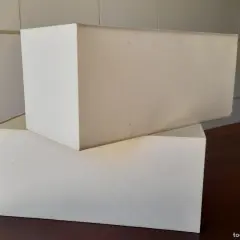 Dos pantallas de lámpara de pared apiladas, de tela blanca, listas para dar luz.