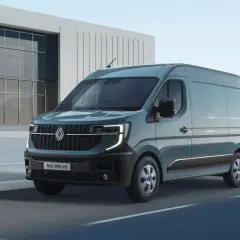 Nowy Renault Master 4 w kolorze morskim, z nowoczesnym designem, przemierza drogę obok futurystycznego budynku.