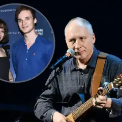 Kuba Sienkiewicz gra na gitarze, a w tle widać jego dzieci.