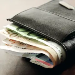 Schwarzes Lederportemonnaie mit Euro-Scheinen. Die Scheine deuten auf die Gehaltszahlung nach dem tarifvertrag wohnungswirtschaft eingruppierung hin.