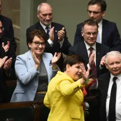 Kiedy rządził PiS, Beata Szydło w żółtej marynarce i Jarosław Kaczyński w garniturze pozdrawiają tłum.