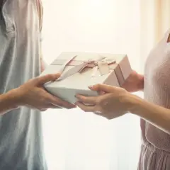 Mężczyzna wręcza kobiecie prezent. To może być miła niespodzianka z okazji 25 rocznicy ślubu.