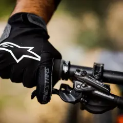 Mano enguantada con logo Alpinestars en manillar de bici. ¡Ya me duermen las manos en la bici!