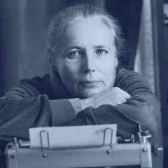 Agnieszka Osiecka przy maszynie do pisania, w tle regał z książkami. Jej teksty wciąż inspirują.