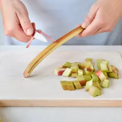 Hände schälen Rhabarber für herzhafte rhabarber rezepte hauptgerichte. Gekochter Rhabarber passt gut zu Fleisch.
