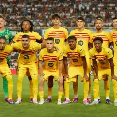 Drużyna FC Barcelona w żółtych strojach, z kapitanem na czele, gotowa do gry.