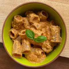 Rigatoni conditi con un cremoso pesto con mandorle, guarniti con basilico fresco.