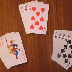 Na stole leżą karty: jopek, as, dwójka, trójka ósemek, czwórka pików i dziesiątka pików.