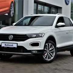 Biały Volkswagen T-Roc, jeden z popularnych volkswagen suv modele, zaparkowany przed salonem.