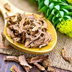 Radice di Rhodiola Rosea essiccata su un cucchiaio di legno. Informarsi sulle controindicazioni prima dell'uso.