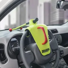 Un antivol de volant Bullock Defender est installé. Il est jaune vif avec une poignée rouge. Il n'y a pas de clé visible, ce qui peut faire penser à comment débloquer un volant sans clé.