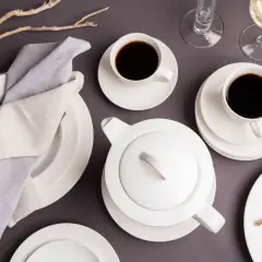 Elegancka zastawa stołowa z filiżankami kawy i dzbankiem. Ile herbaty sypanej na kubek? To pytanie pozostaje bez odpowiedzi, ale kawa wygląda apetycznie.