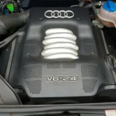 Silnik V6 2.4 w Audi A4 B6. Widoczna osłona silnika z logo Audi i oznaczeniem V6-2.4.